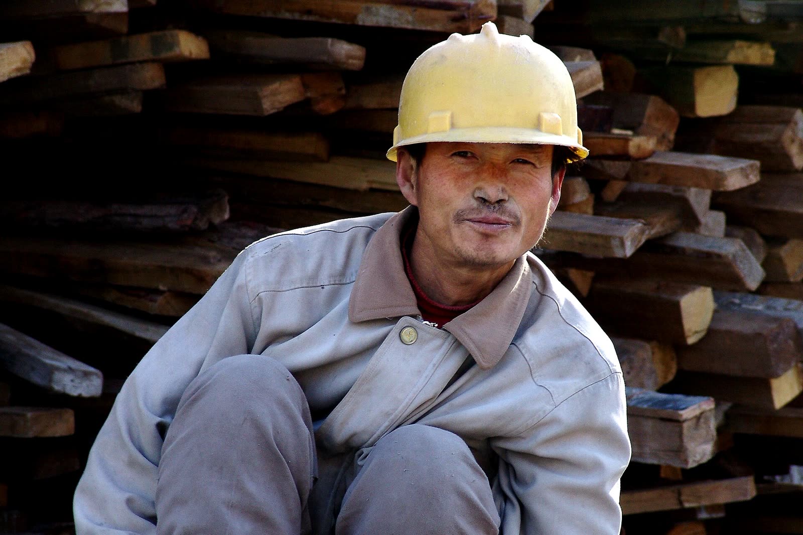 Mitarbeiter in Arbeitskleidung mit Helm